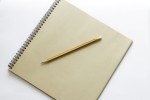 brown notebook and pencil